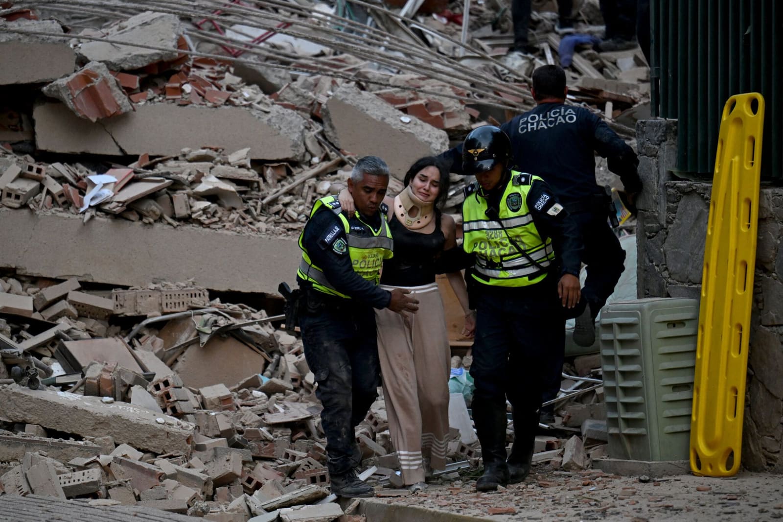 Policías ayudan a un sobreviviente herido entre los escombros del terremoto en Venezuela